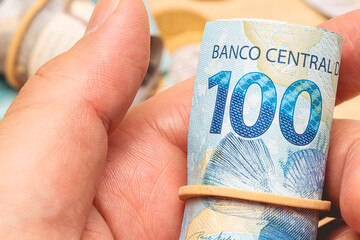 Dinheiro, Brasil, Reais, Real Brasileiro, Real. Um homem segurando uma nota de 100 Reais.