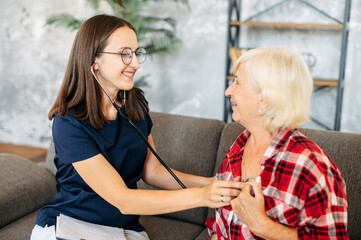 Therapist check up heartbeat of elderly woman with a stethoscope at home or in hospital. Medical insurance care