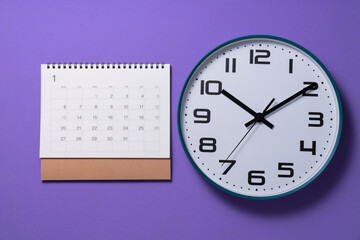 close up of calendar page and clock on the purple table background, planning for business meeting or travel planning concept