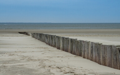Fototapeta na wymiar Wooden breakwater along the Dutch coast of Ameland
