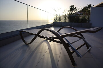wooden sun lounger with a view on the Atlantic ocean, at sunset