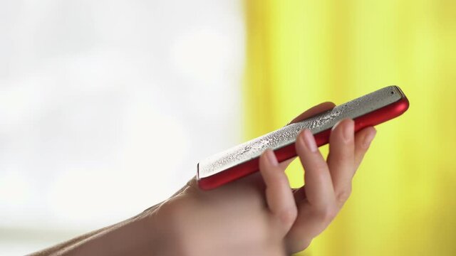 Close-up of woman hand using wet wipe and sanitizer to clean cell phone screen. People cleaning and disinfecting mobile telephone monitor to kill virus and germs. Female hands holding smartphone