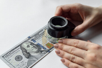 Young woman hand with magnifying glass and dollars, money check. Concept - Verify authenticity money. Evaluate paper from which banknotes are made. 3D illustration