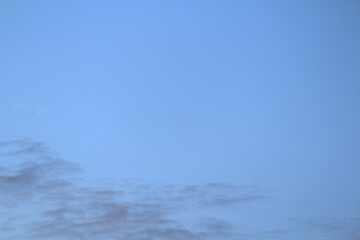 Clouds in the sky are illuminated from below by the red light of the sun. Sunset or sunrise scene at dusk