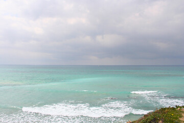 sailing boat on the beach, blue sea water, and dark sky