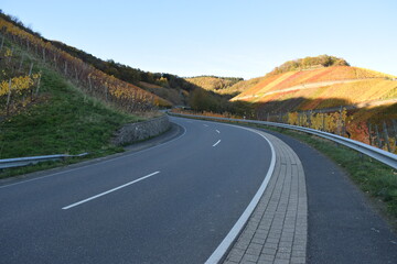 kurvige Straße durch die Weinberge ins herbstlich bunte Ahrtal bei Dernau