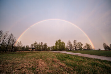 Naklejka premium beautiful rainbow above countryside roads