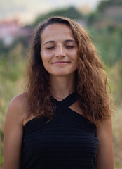 Authentic portrait of smiling brunette female with eyes closed