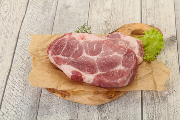 Raw pork steak over wooden board