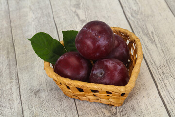 Plum heap in the wooden basket