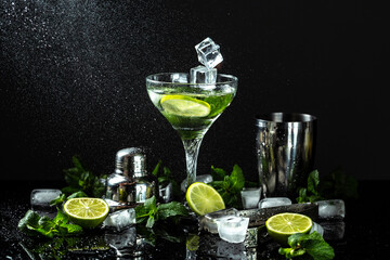 summer citrus refreshing drinks Mojito cocktail with lime, mint and ice in jar glass on dark background. drink in freeze motion, drops in liquid splash. The concept of cocktails, lemonade