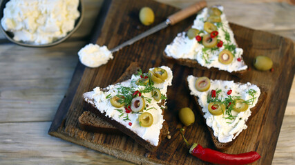 Selective focus. Macro. Mascarpone sandwiches with olives and spices.