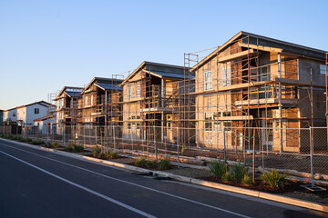 Exterior of New home construction with scaffolding scaffolds; single family homes under construction in California	