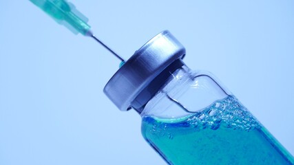 Filling syringe with vaccine from vial, close up. Administrating medication with medical needle syringe and vaccine injection for patient vaccination in medical hospital.  Health and medical concepts.