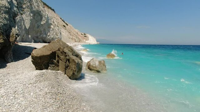Slow motion video from beautiful paradise pebble beach of Lalaria with famous rocky arch and turquoise clear sea in Skiathos island, Sporades, Greece