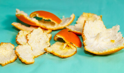 Peel of citrus fruits, oranges and tangerines on a turquoise background.