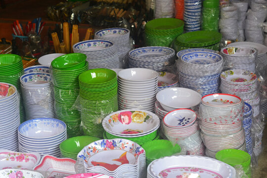 Multi-colored Plates And Bowls Of Melamine In Stacks Stand On The Counter In The Asian Market