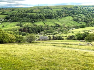 Landscape view, looking across, Shibden Valley, with meadows, fields, farms and distant hills on a cloudy day  in, Shibden, Halifax, UK