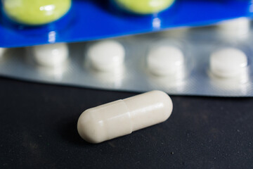 Lots of different pills on the table in close-up.