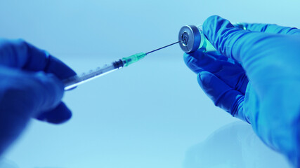 Filling syringe with vaccine from vial, extreme macro. Administrating medication with sterile...