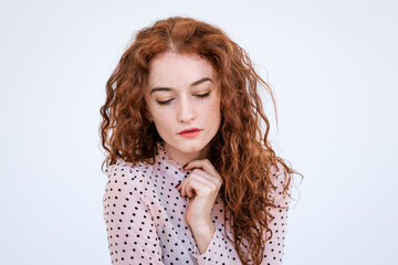 Portrait of a sad young woman with red hair close up