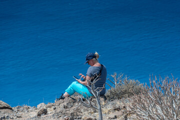 Frau bei Outdoor Handy Nutzung hoch &uuml;ber dem Atlantik