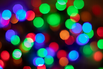 Glowing and festive colored light spots. In camera and lens bokeh. Christmas fairy LED lights defocused. 