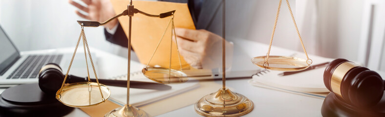 Business and lawyers discussing contract papers with brass scale on desk in office. Law, legal services, advice, justice and law concept picture with film grain effect