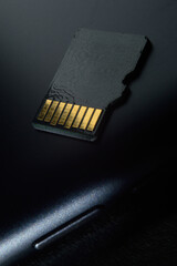 Flash memory storage concept: Micro SD card on the background of a smartphone. A memory card is...