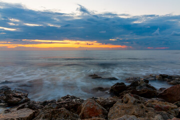 Obraz premium Long exposure of water against the background of a sea sunset.