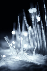 illuminated winter crystal icicles in snow at dark night
