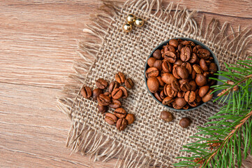 Grains of coffee and a branch of a christmas tree on a wooden table