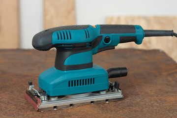 Electric sheet finishing sander on old rusty metal sheet., on background oriented strand board