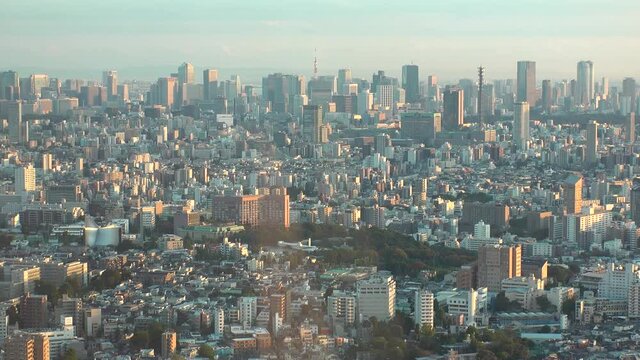 TOKYO, JAPAN : Aerial high angle sunset CITYSCAPE of TOKYO. View of buildings around Shinjuku and Minato ward. Japanese urban metropolis concept. Long time lapse zoom out shot dusk to night.