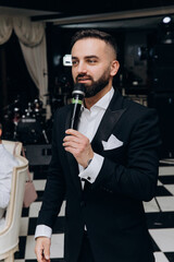 Portrait of the groom. The groom is expecting a meeting with the bride. Photoshoot of a successful businessman in a tuxedo.