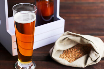 Home brewing concept. Make a lager beer with natural ingredients. Still life with beer and barley on wooden background