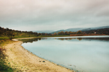 Beautiful rural landscape in Europe. Sunny nature with meadow and colorful forest. Orange trees on hillsides.