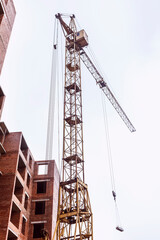 Tower crane on the background of the structure. Construction of a multi-storey building