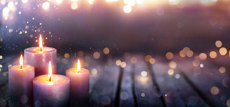 Abstract Advent - Four Purple Candles With Soft Blurry Lights And Glittering On Flames