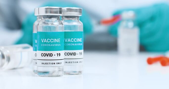 Close up of doctor or nurse in latex blue rubber gloves applying coronavirus vaccine into the syringe during the coronavirus pandemic, SARS-CoV,COVID-19