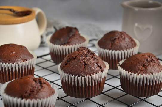 Chocolate muffins in a white paper capsule, standing on the grate.