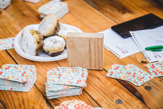 Board games on wooden table and sweet cupcakes