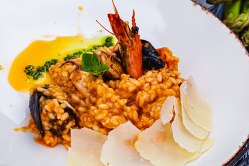 Risotto with seafood and parmesan cheese on white plate.