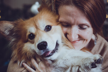 girl and dog embrace one another