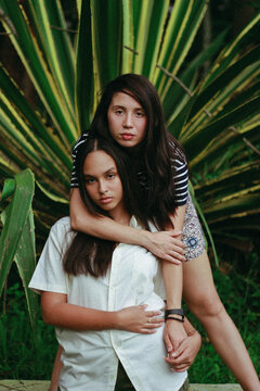 Portrait Of Two Sisters Standing Against Plants