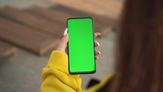 Handheld Camera: Point of View of Woman at street Using Phone With Green Mock-up Screen Chroma Key Surfing Internet Watching Content Videos Blogs Tapping on Screen