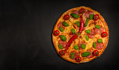 Creative design. Pizza time. Pizza clock and peppers clock hands. Place for copy and paste. Black blackboard as background. Flat lay.
