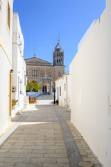 Narrow street in Lefkes village on Paros Island. Church of Agia Triada in background. Greece