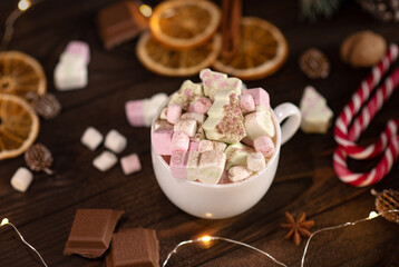 New Year background. A cup of cocoa with marshmallows on a brown wooden background, top view