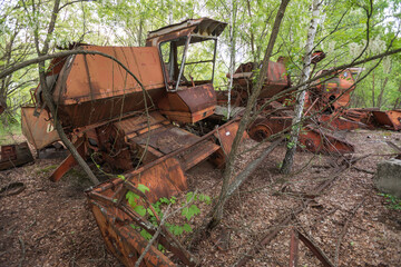 Fototapeta na wymiar Abandoned radioactive harvesters, old rusty machines near abandoned village Kopachi